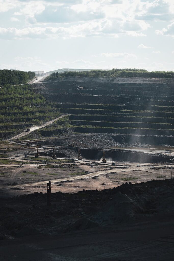 Expansive aerial capture of a large open pit mine on a sunny day.